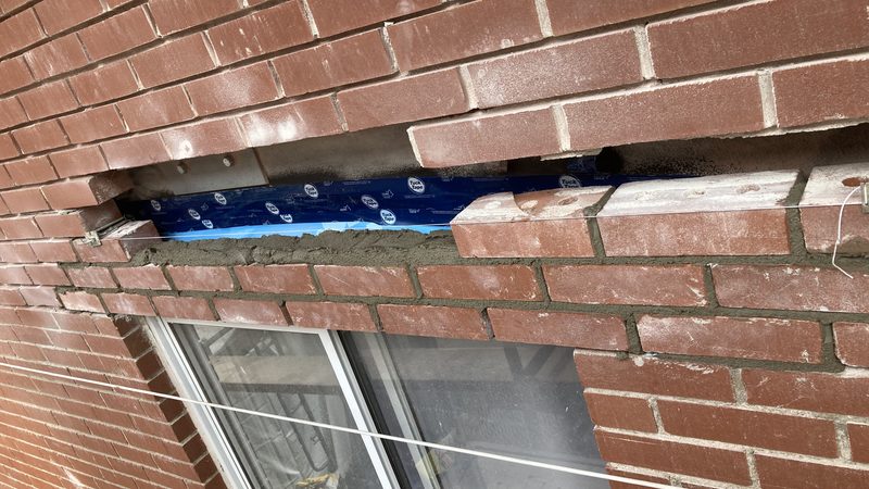 Le linteau d'acier galvanisé neuf en place sous la brique
